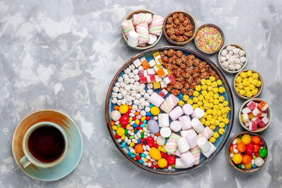 top-view-candy-composition-different-colored-candies-with-marshmallow-inside-pots-with-tea-white-desk-sugar-candy-bonbon-sweet-confiture