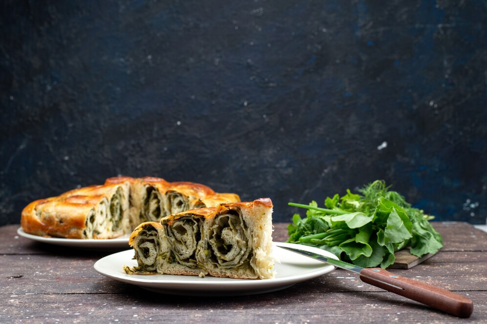 front-view-cooked-greens-pastry-inside-plates-with-fresh-greens